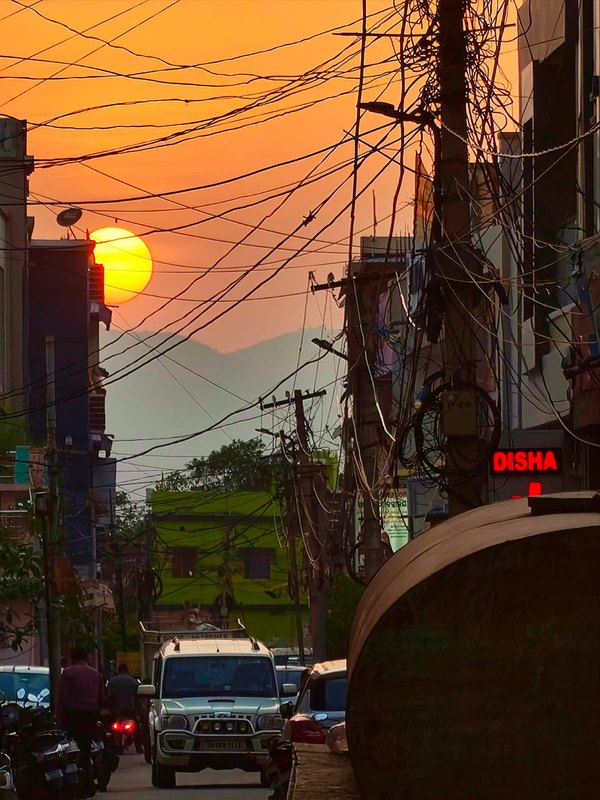 Sunset over rooftops and power lines