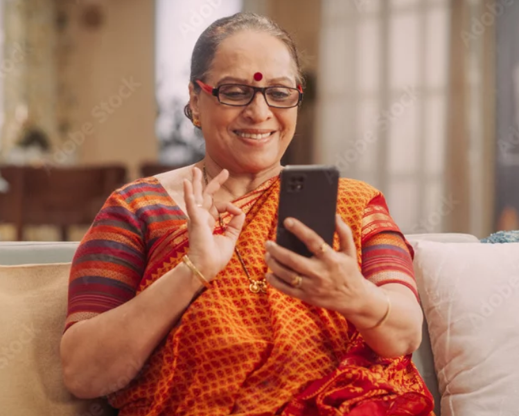 Rampyari, a grandmother in her 70s, smiling at a phone